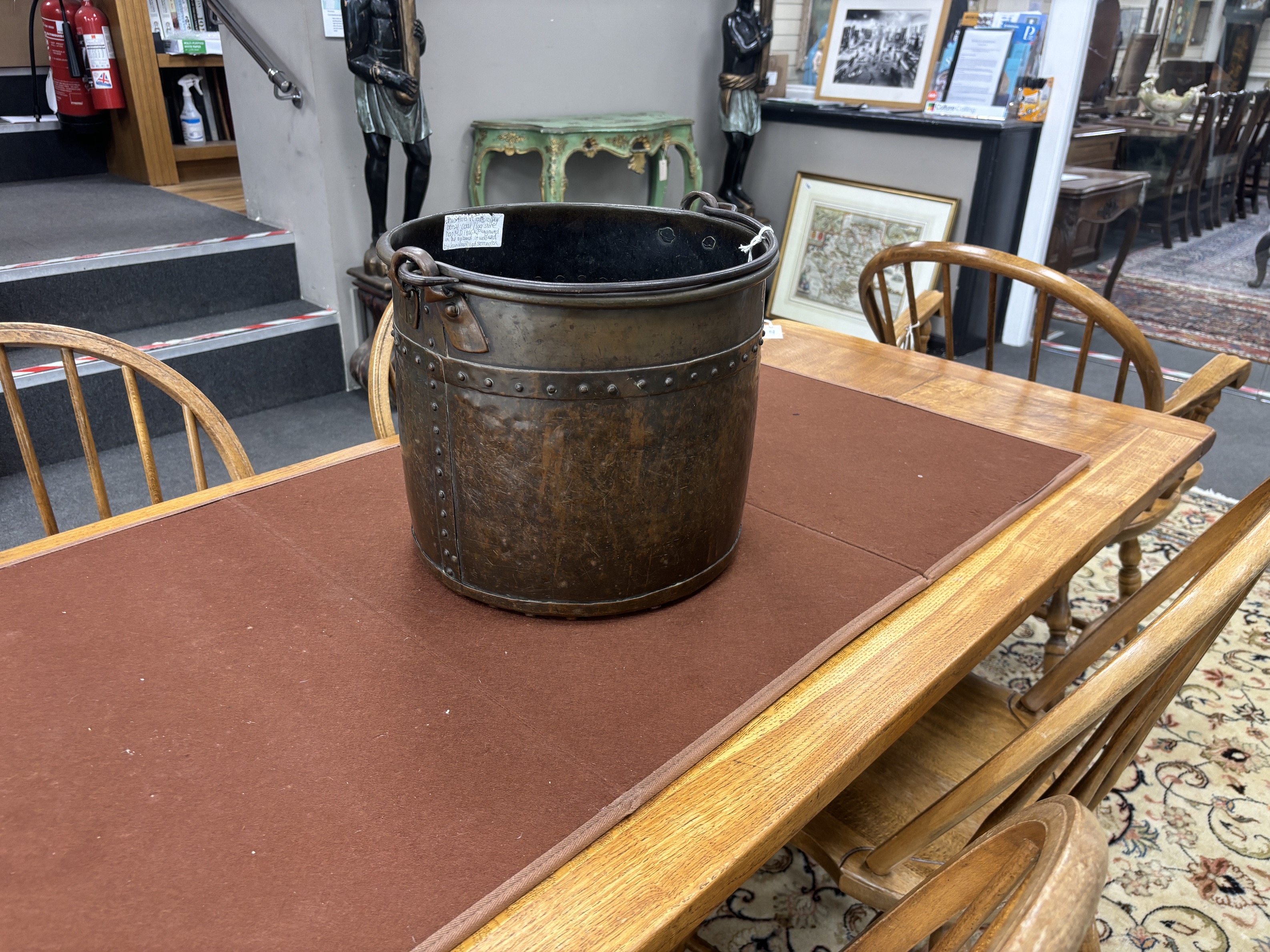 A late Victorian Arts and Crafts hammered copper coal bucket with iron swing handle, diameter 34cm, height 31cm.